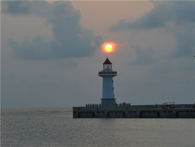 三沙市政府所在地永兴岛的港湾堤头灯桩迎夕阳.jpg