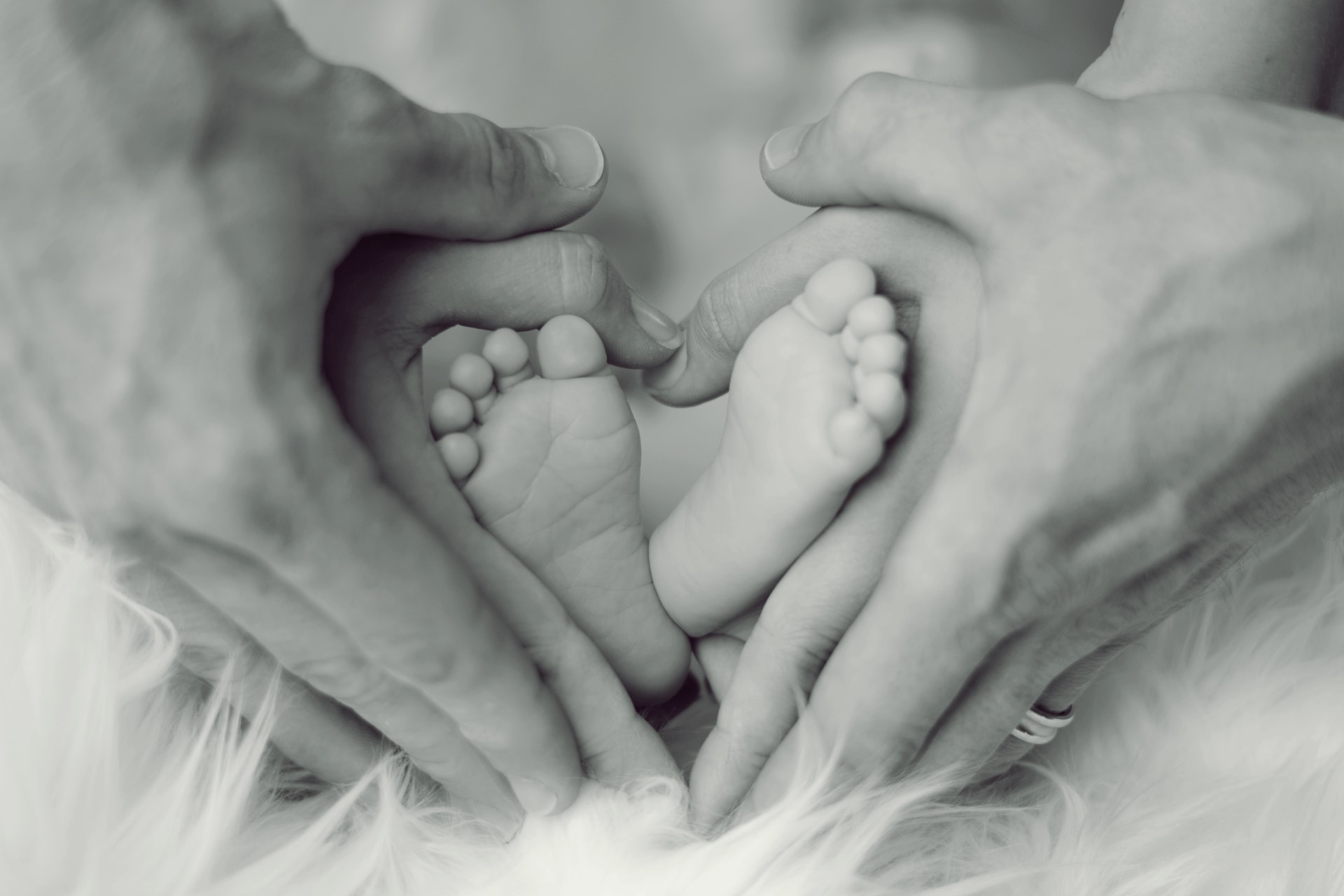 grayscale-photo-of-baby-feet-with-father-and-mother-hands-in-733881.jpg