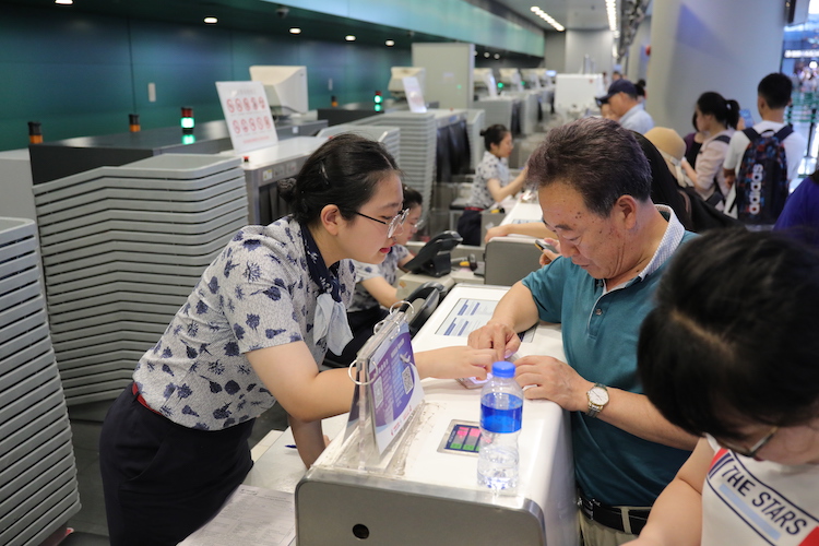 东航地面服务人员正在值机柜台向旅客解释航班情况jpg