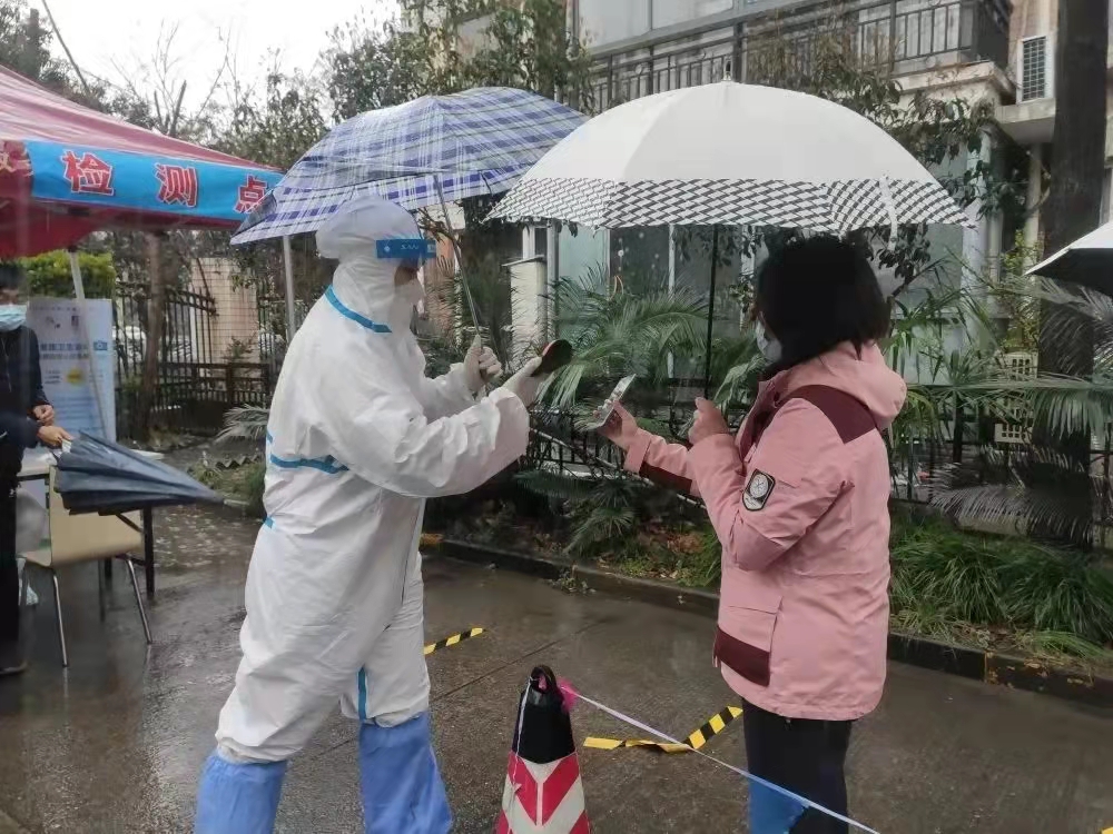 徐汇民防志愿者雨中为居民核酸登记.jpg